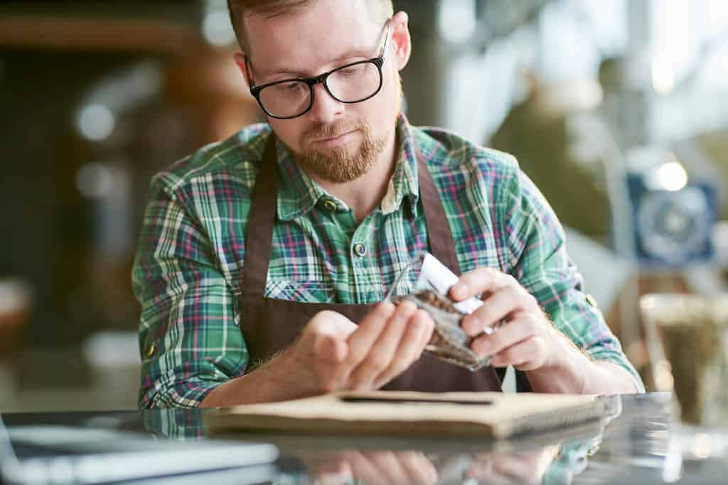 Barista pouring coffee beans into hand