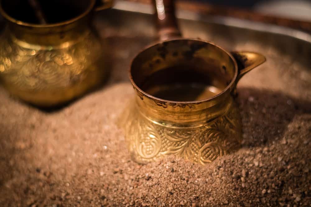 traditional turkish coffee being prepared in hot sand